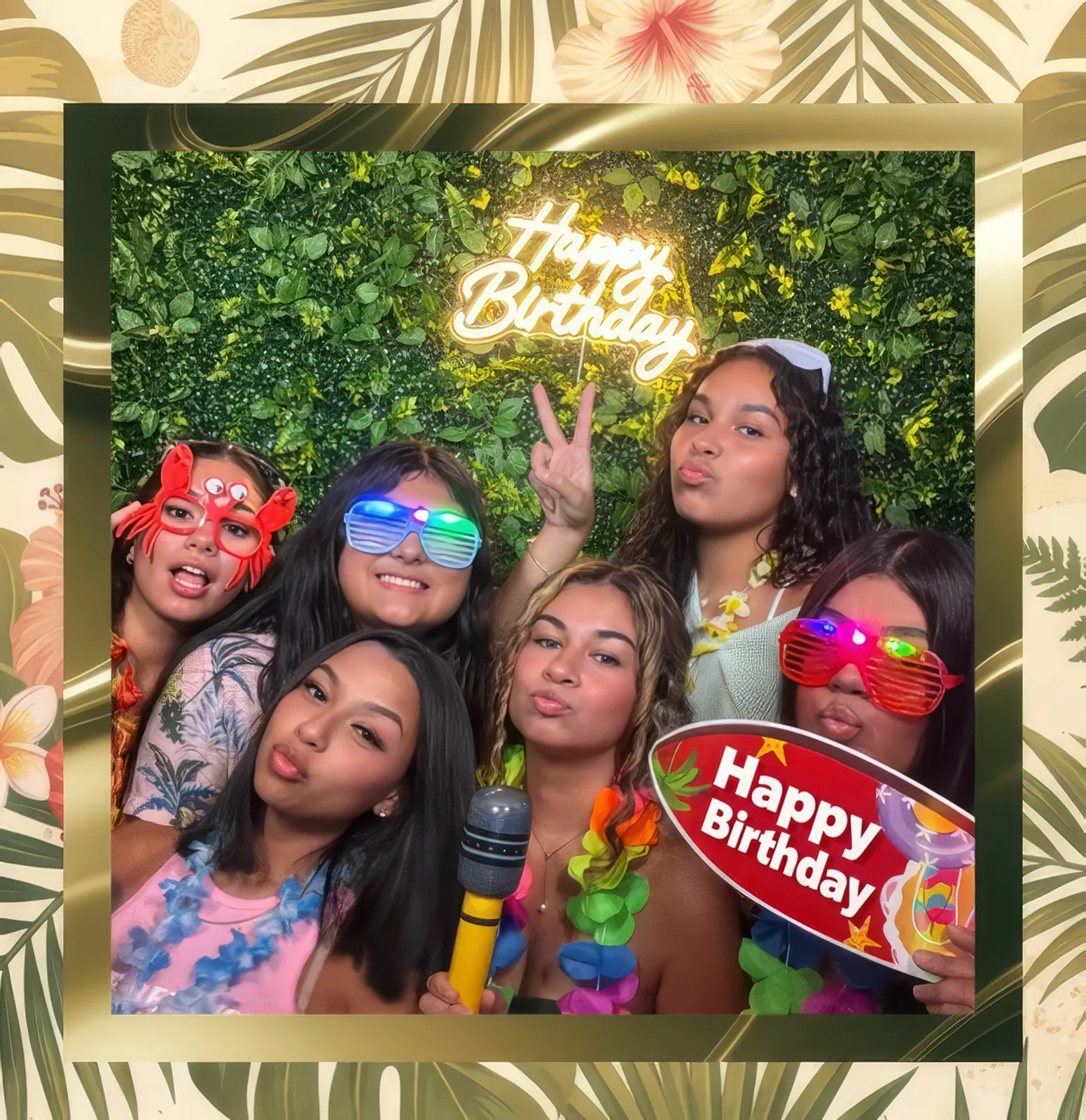 Friends posing in a Happy Birthday photo booth frame